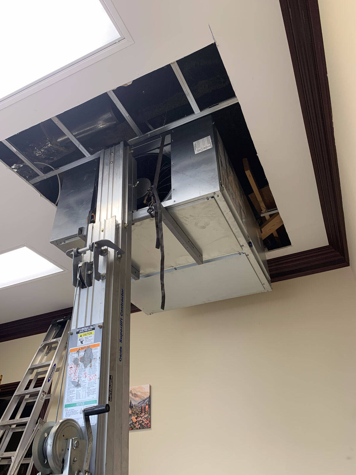 Air handler being lifted into a commercial ceiling
