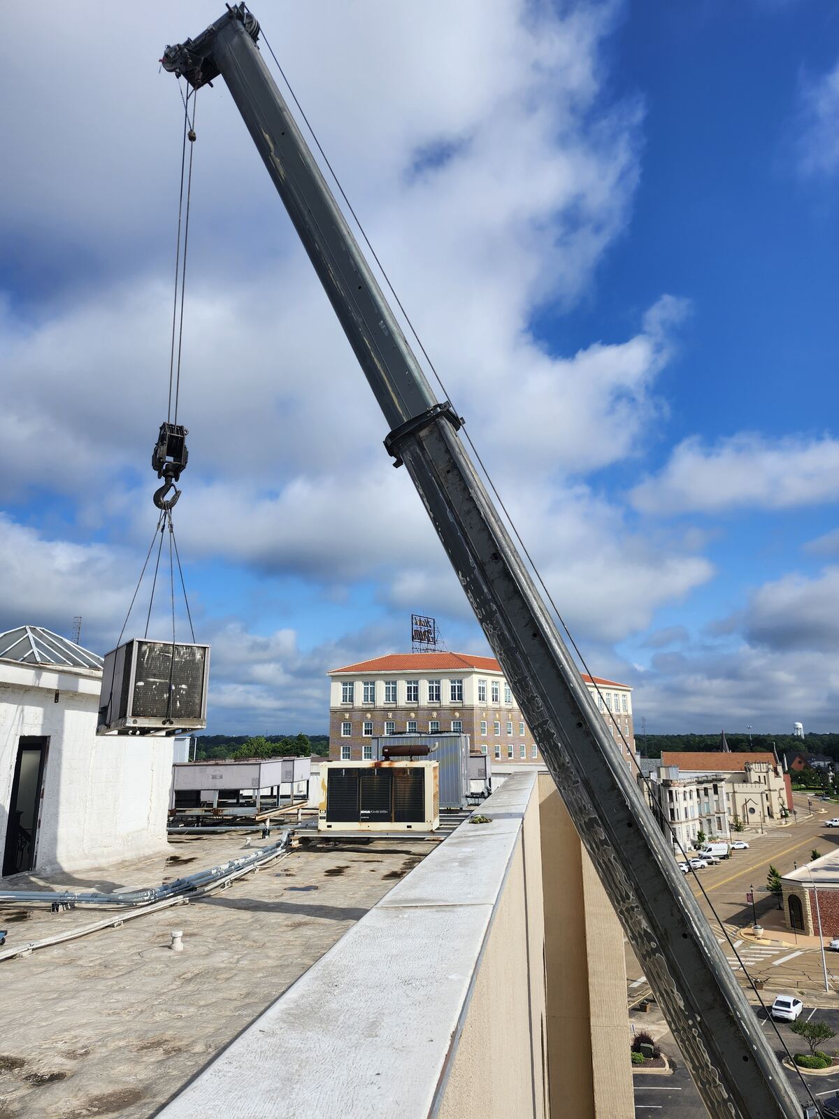 Crane setting a commercial condenser on a downtown Texarkana roof